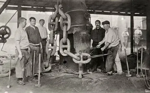 Historical photograph of metalworkers forging anchor chain links at Netherton forge in 1910
