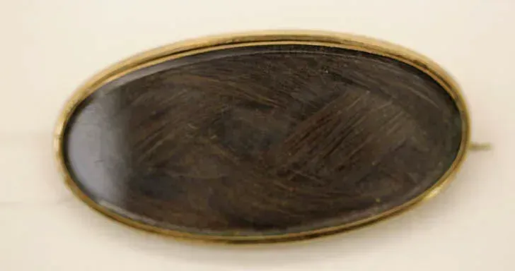 Broche de luto victoriano de 1847 con mechón de cabello en montura metálica