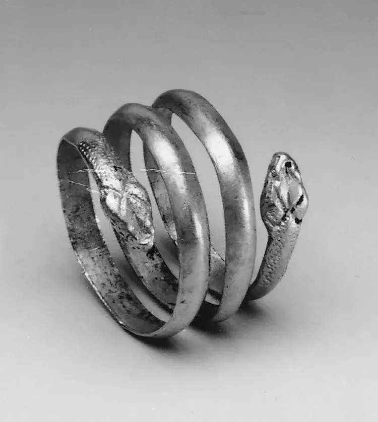 Древнегреческое золотое украшение в форме змеи, повторяющей анатомию: тело обвивает, голова спереди